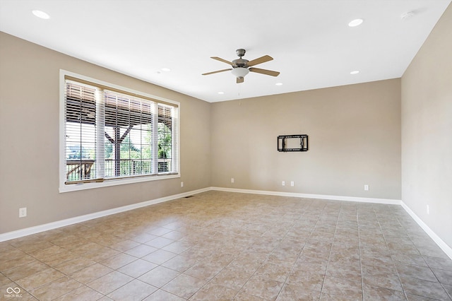 empty room with ceiling fan and light tile patterned floors