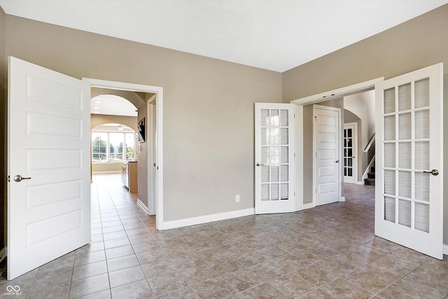 unfurnished room featuring french doors and light tile patterned floors