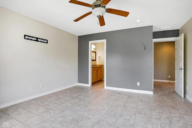 tiled spare room with ceiling fan