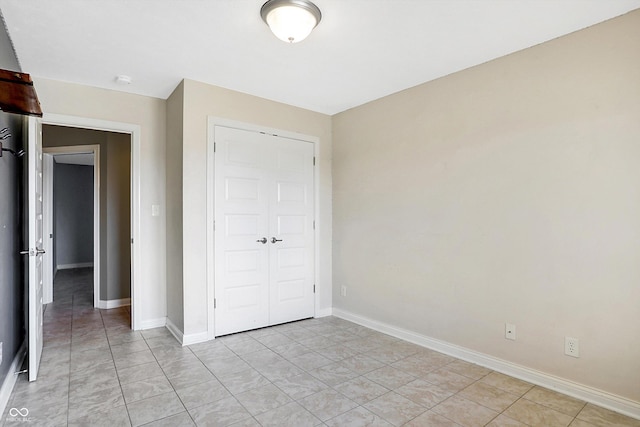 unfurnished bedroom featuring a closet and light tile patterned floors