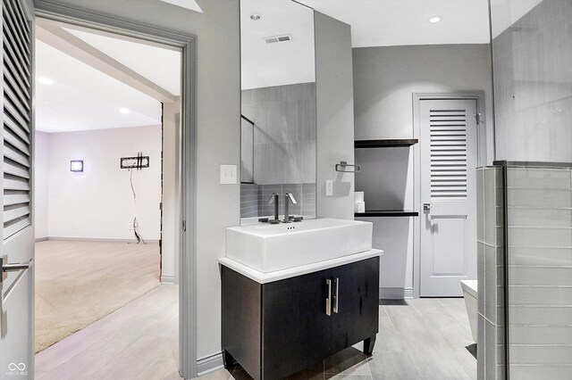 bathroom with vanity, backsplash, and walk in shower