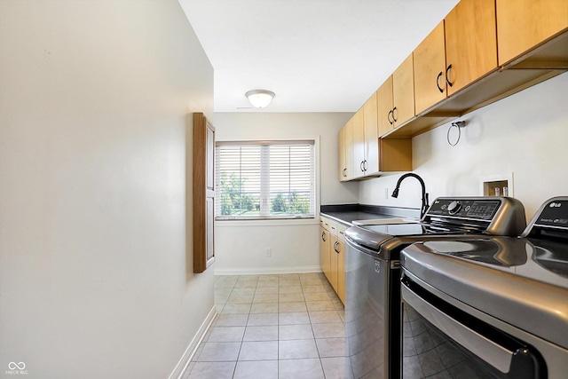 laundry area with cabinets, washer and clothes dryer, and light tile patterned flooring