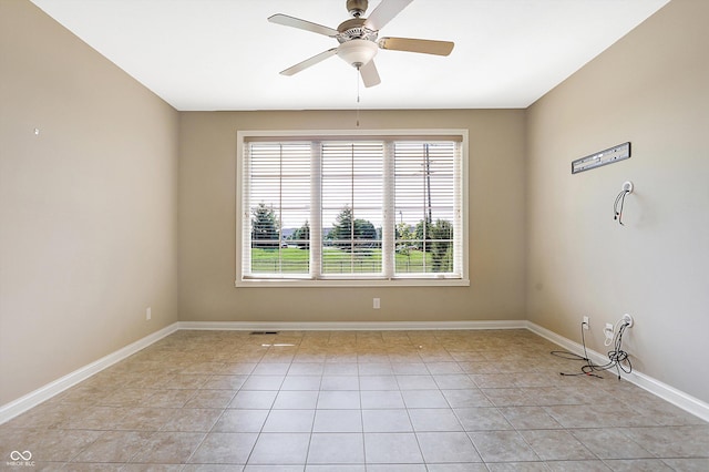 tiled spare room with ceiling fan