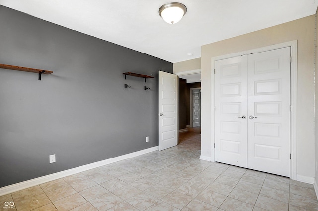 unfurnished bedroom featuring a closet and light tile patterned floors