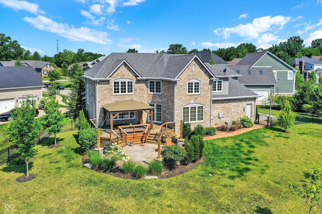 rear view of property with a lawn, a gazebo, a deck, and a patio