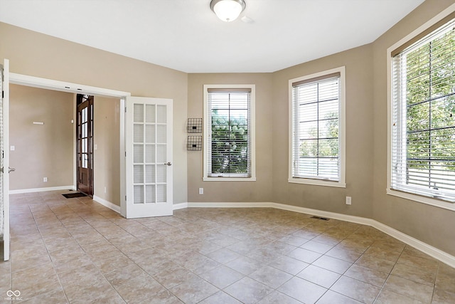 tiled spare room with french doors