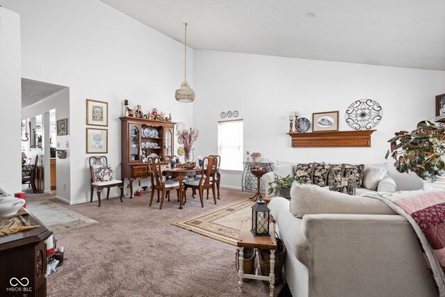 carpeted living room featuring baseboards and high vaulted ceiling