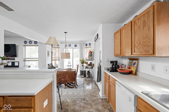 kitchen featuring dishwasher, light countertops, plenty of natural light, and visible vents