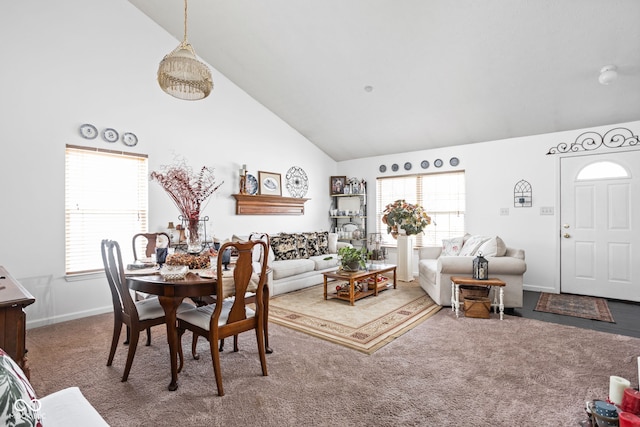 carpeted dining area featuring a healthy amount of sunlight, baseboards, and high vaulted ceiling