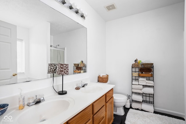 bathroom with a sink, visible vents, a shower stall, and double vanity