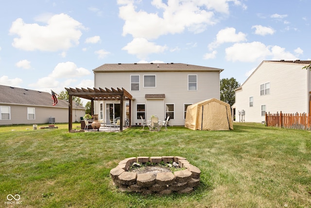 rear view of property with a fire pit, fence, a yard, a pergola, and a patio