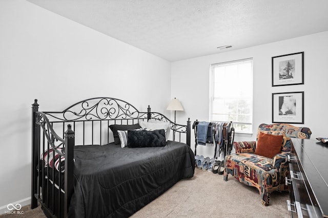 carpeted bedroom with visible vents and a textured ceiling