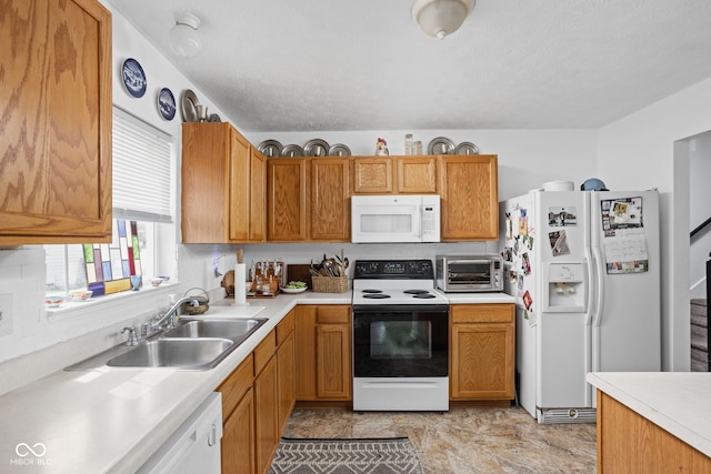 kitchen with a toaster, white appliances, light countertops, and a sink