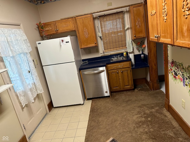 kitchen with stainless steel dishwasher, sink, white fridge, and light colored carpet