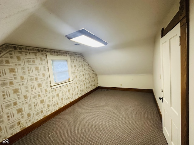 additional living space featuring lofted ceiling, baseboards, and carpet floors