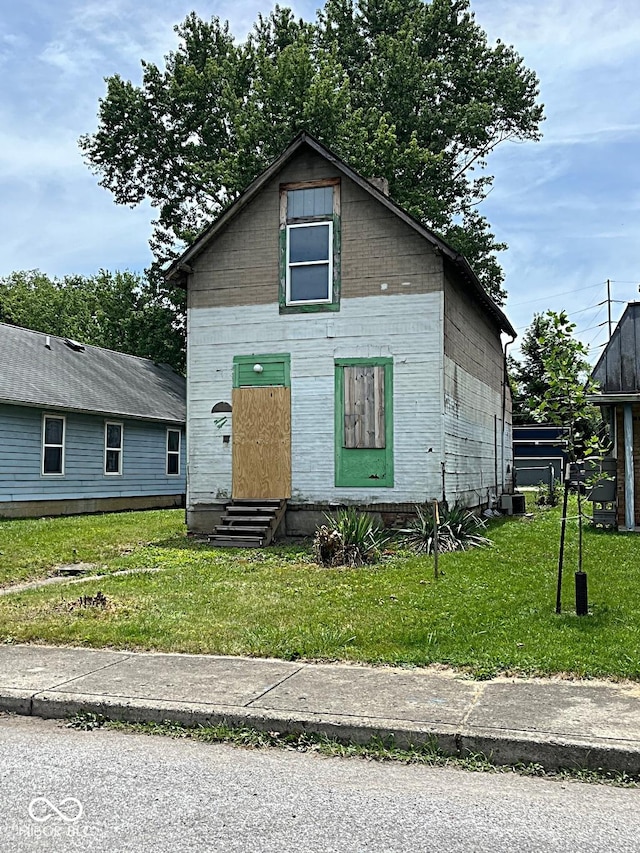 view of front of home with central AC unit and a front lawn