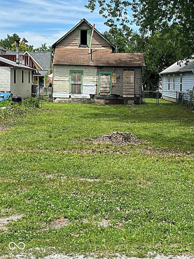 rear view of house featuring a yard