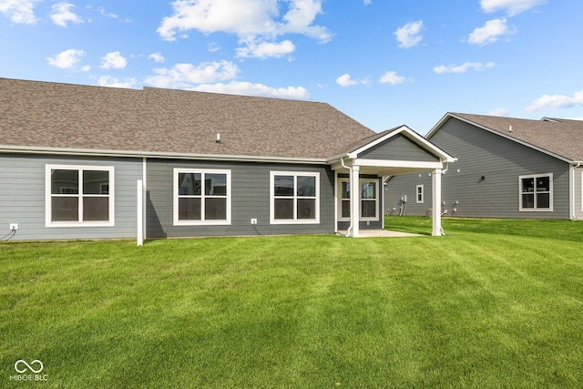 rear view of house featuring a lawn