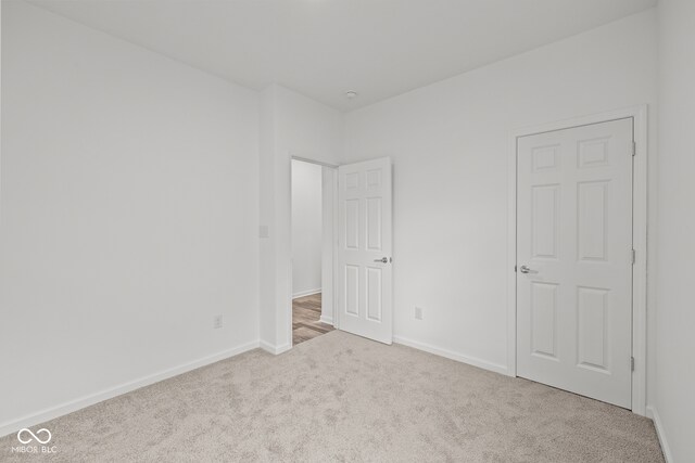 unfurnished room featuring light carpet