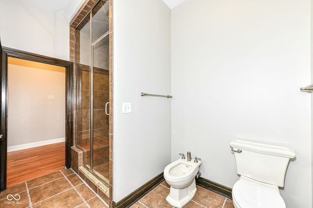 bathroom featuring toilet, an enclosed shower, and a bidet