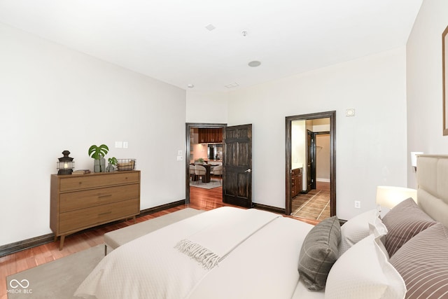 bedroom with light hardwood / wood-style flooring and ensuite bath