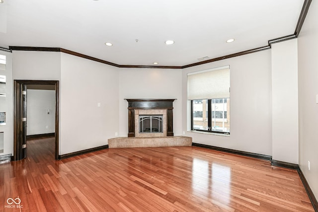 unfurnished living room featuring crown molding and wood-type flooring