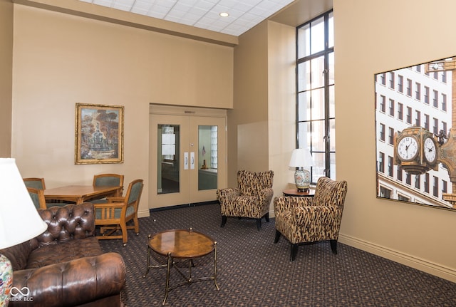 interior space with carpet flooring, french doors, and a towering ceiling