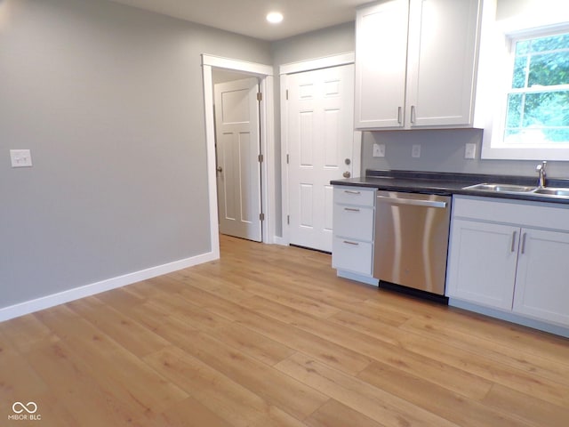 kitchen featuring stainless steel dishwasher, sink, light hardwood / wood-style flooring, and white cabinets