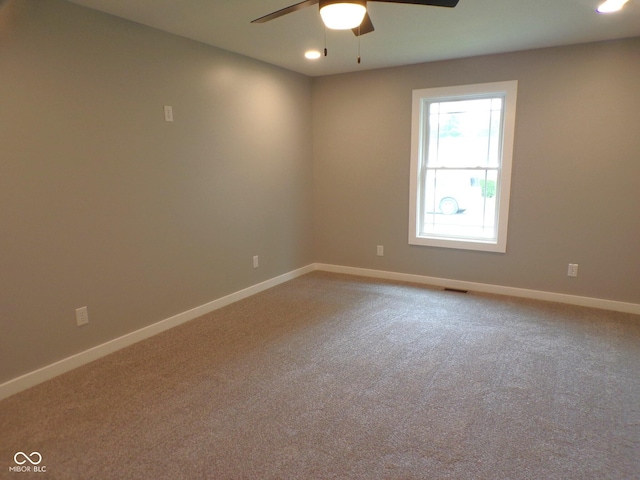 carpeted spare room with ceiling fan