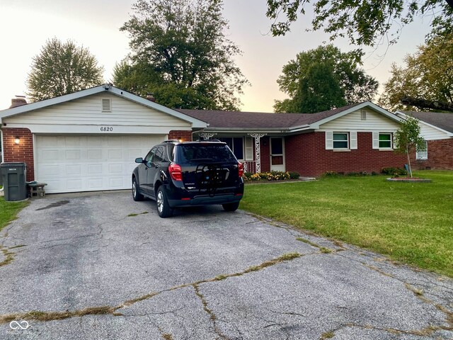 single story home featuring a garage and a yard