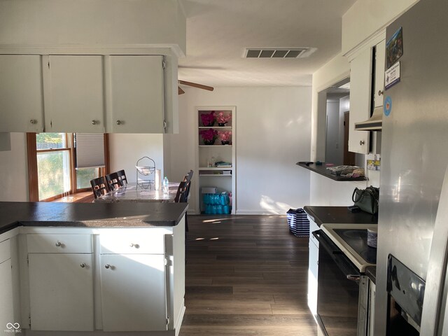 kitchen featuring stainless steel refrigerator with ice dispenser, dark wood-type flooring, white cabinetry, and range with electric stovetop