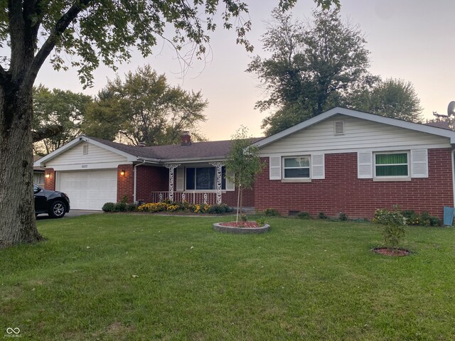 single story home featuring a garage, a yard, and covered porch