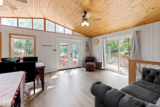 living area featuring french doors, lofted ceiling, wood ceiling, wood finished floors, and plenty of natural light