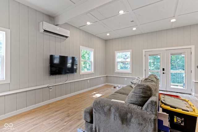 living room with beamed ceiling, wood finished floors, french doors, a wall mounted AC, and recessed lighting