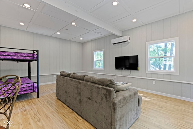 living area featuring a wall unit AC, baseboards, wood finished floors, and recessed lighting