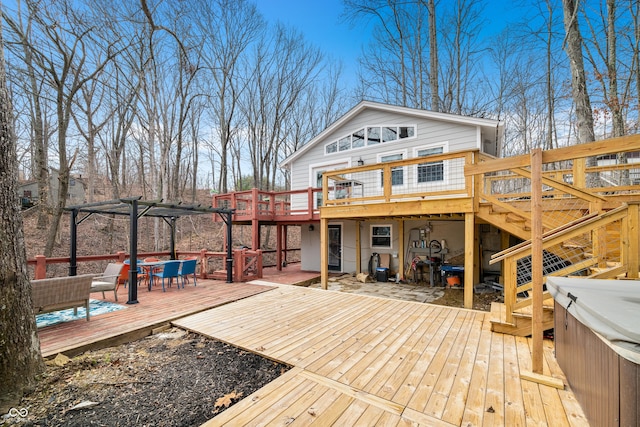 back of house featuring stairway, outdoor dining area, a hot tub, and a wooden deck