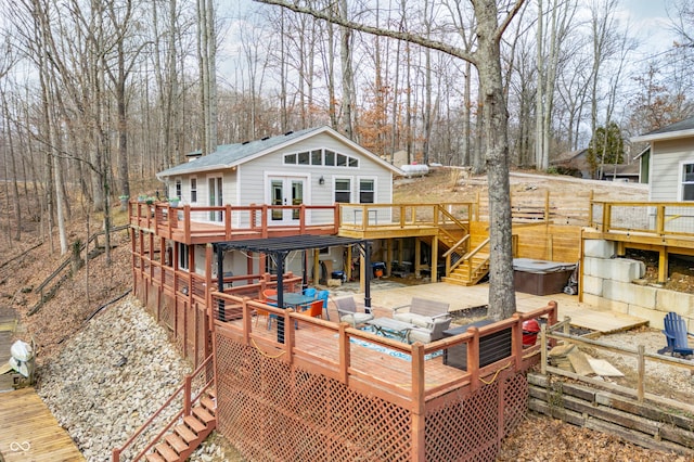 rear view of house featuring stairway, french doors, a hot tub, and a wooden deck