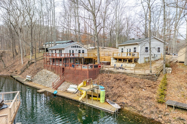 dock area featuring stairway and a deck with water view