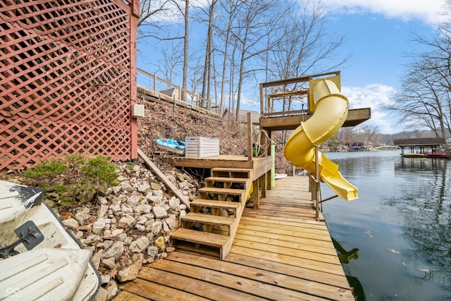 exterior space with a playground, a dock, and a water view