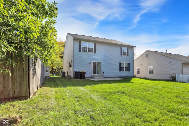 rear view of property with a lawn, entry steps, central AC, and a patio