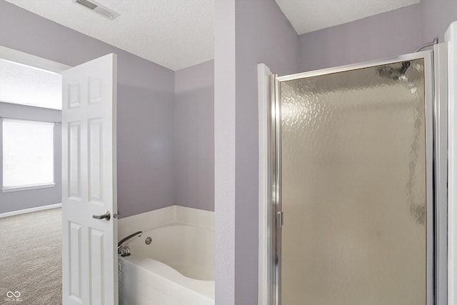 bathroom with visible vents, a stall shower, a textured ceiling, and a garden tub