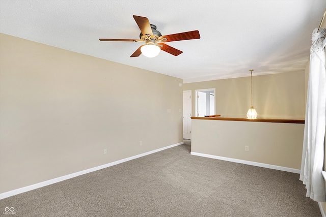 unfurnished room with a textured ceiling, a ceiling fan, carpet, and baseboards