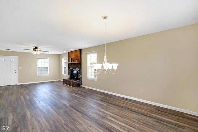 unfurnished living room with a wealth of natural light, a fireplace, dark wood-type flooring, and baseboards