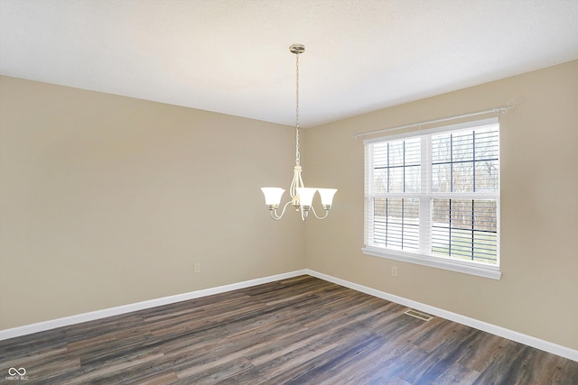 unfurnished room with visible vents, baseboards, a chandelier, and dark wood-style flooring