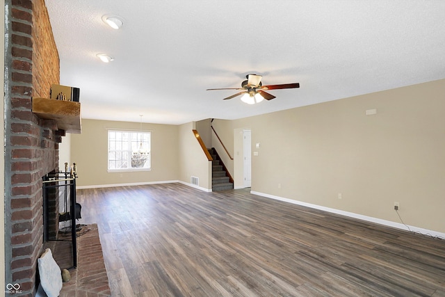 unfurnished living room featuring dark wood-style floors, a fireplace, stairs, and baseboards