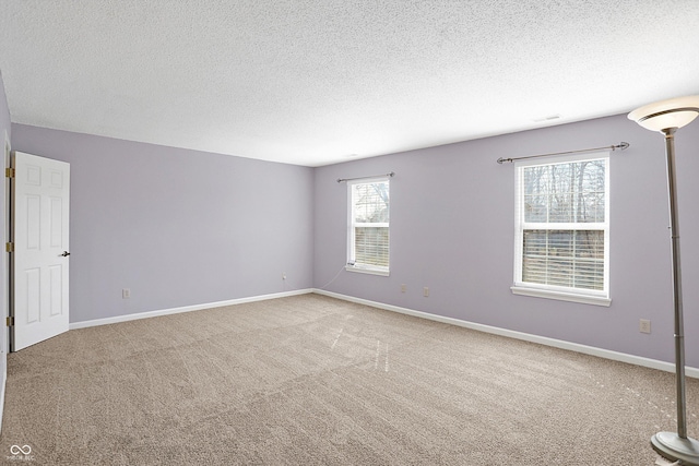 unfurnished room featuring a textured ceiling, baseboards, and carpet floors