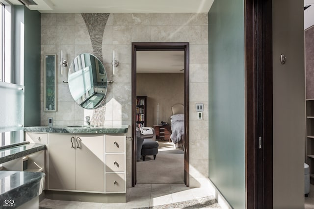 bathroom featuring tile walls, tile patterned floors, and vanity