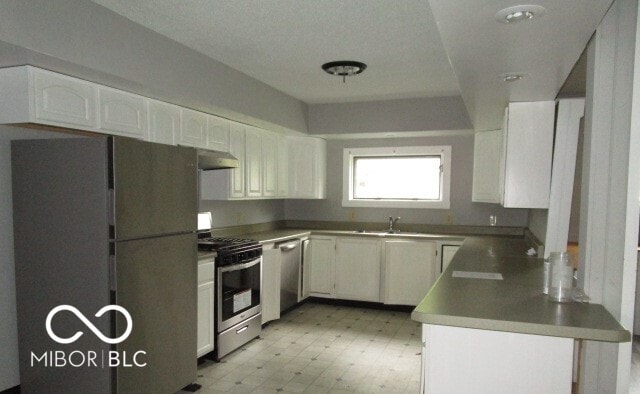 kitchen with light tile patterned flooring, sink, stainless steel appliances, and white cabinets