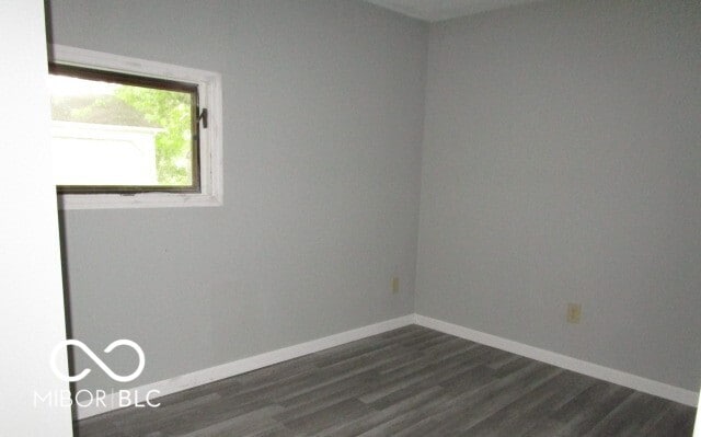 empty room with dark hardwood / wood-style flooring