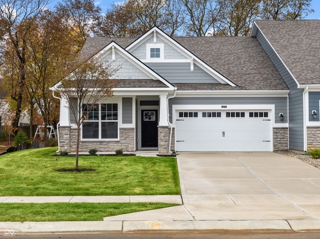 craftsman-style home featuring a garage and a front lawn